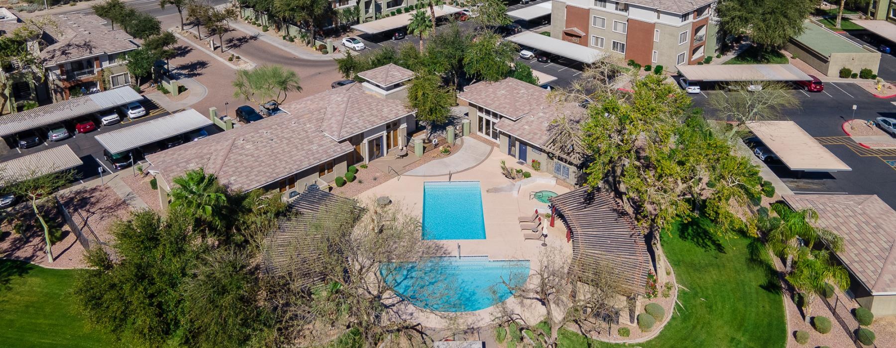 a large courtyard with a pool and buildings in the background