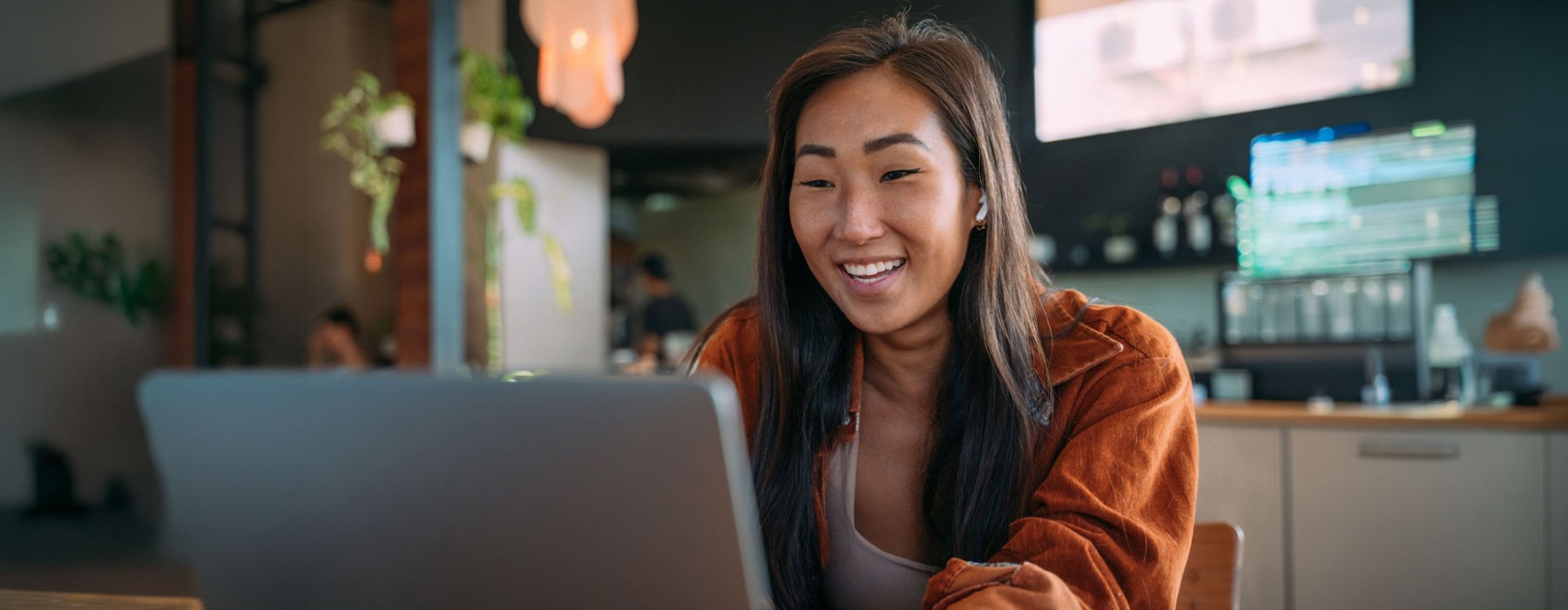 a woman smiling while working on laptop